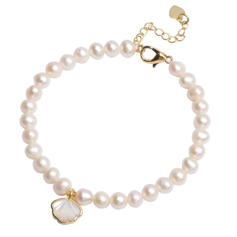 Freshwater pearl bracelet with fan-shaped shell setting and elastic string or extension chain fastening.