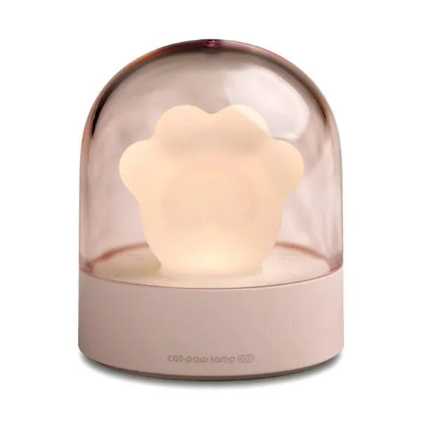 Pink and grey cat paw shaped USB night light with a music box feature on a desktop.