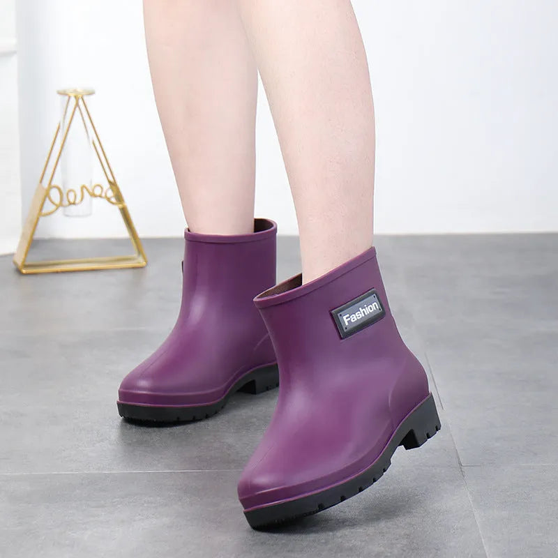 Women's mid-calf PVC rain boot in black with a low heel on a white background.