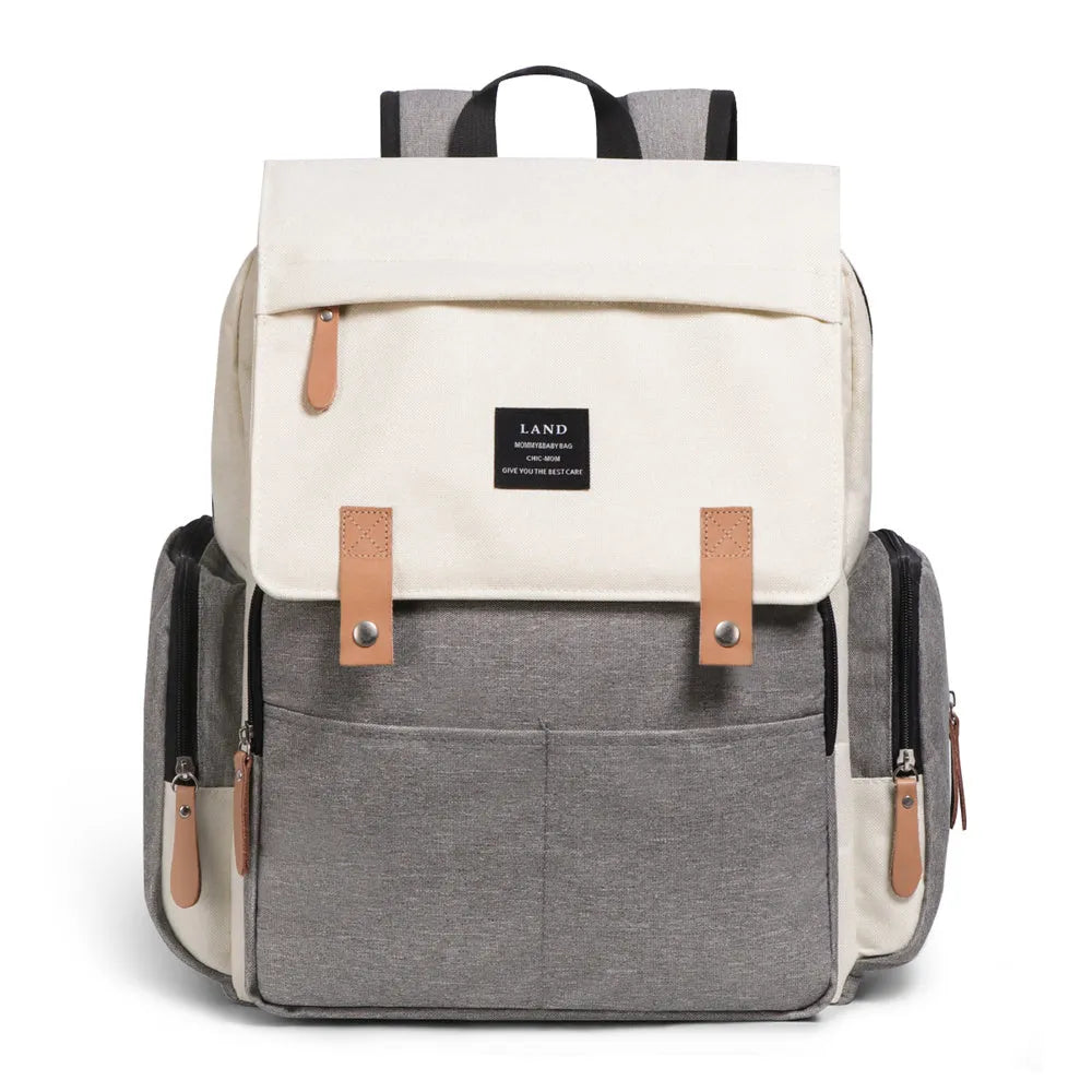 LAND Mommy large grey diaper backpack with changing mat, shown with baby care items.