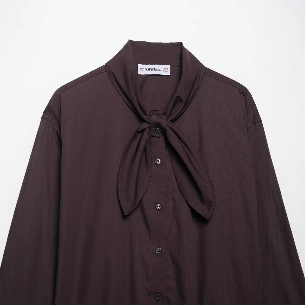Brown women's loose-fit poplin shirt with long sleeves, cardigan style, and a bow tie detail.