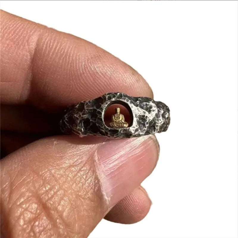 Hand-forged copper Grotto Buddha ring with a rock-textured surface, shown on a size 8 finger.
