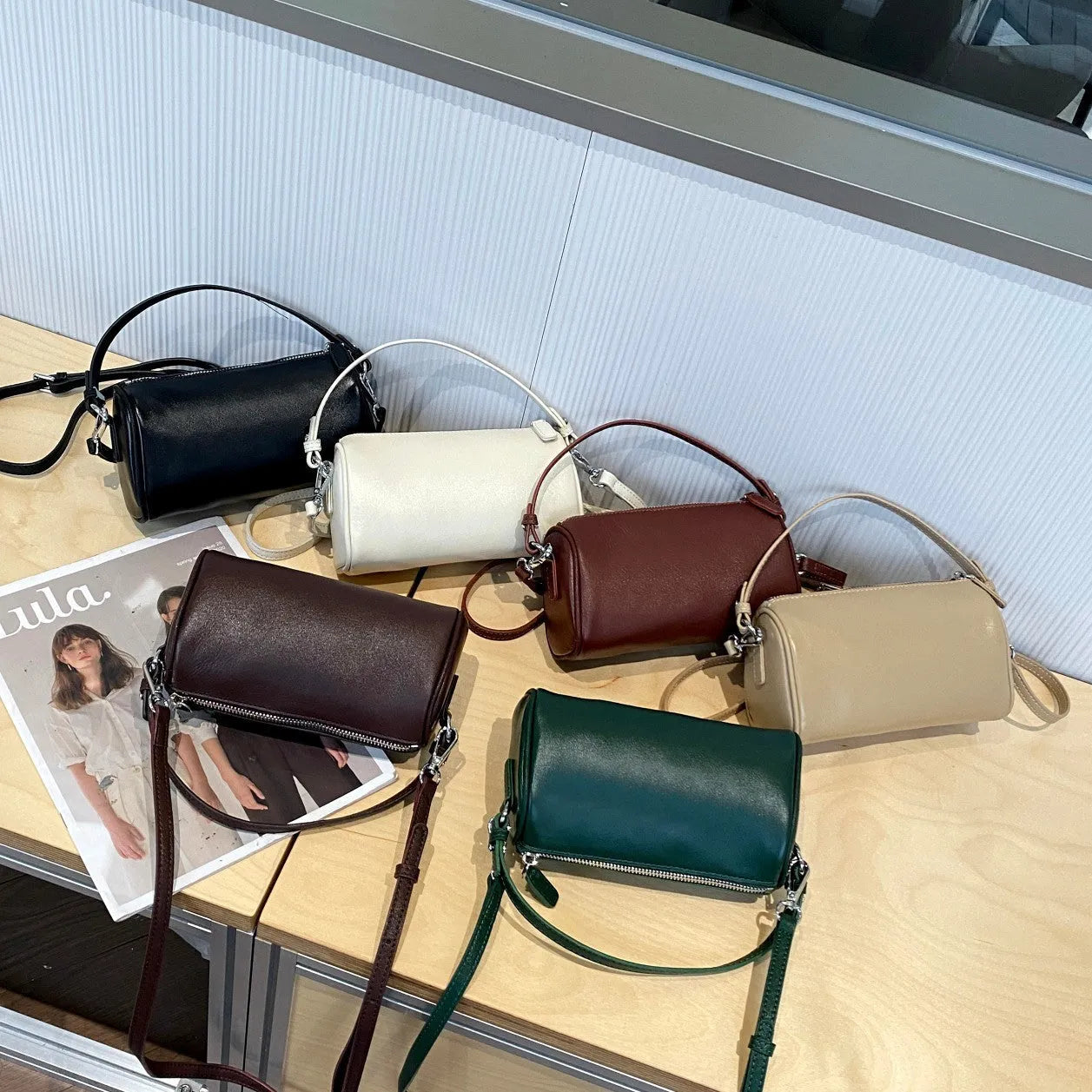 Soft genuine leather cylindrical crossbody bag in street style, shown in black, with a single strap.