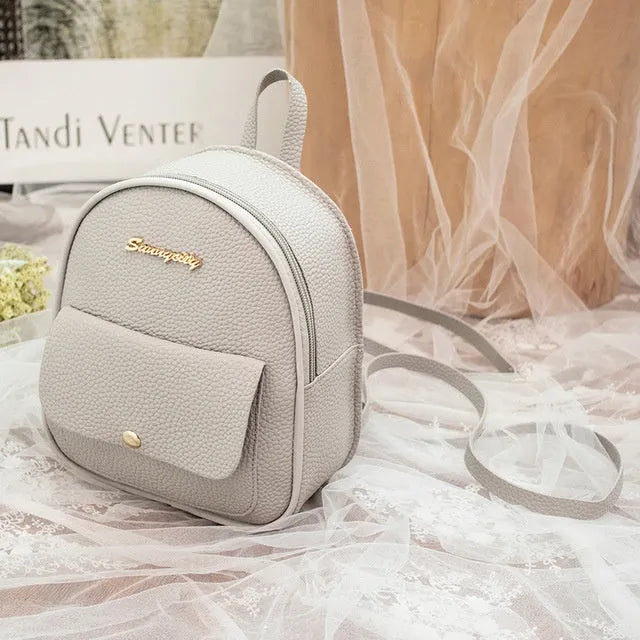 Women's black PU backpack purse with letter design and shoulder strap showing compact 18.5cm length