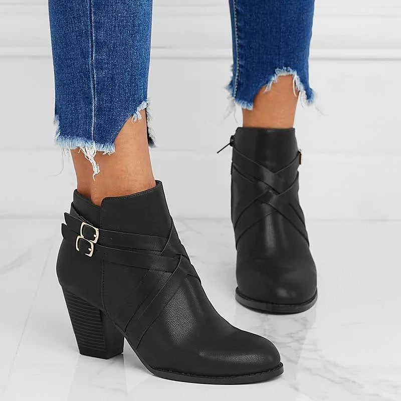Women's black short boot with 7cm heel, side zipper, belt buckle, and rubber sole