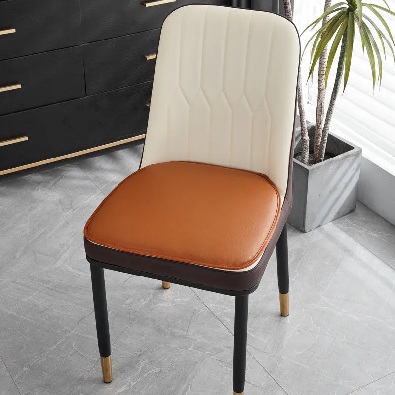 Leather horseshoe-shaped non-slip seat cushion in a solid colour on a chair.