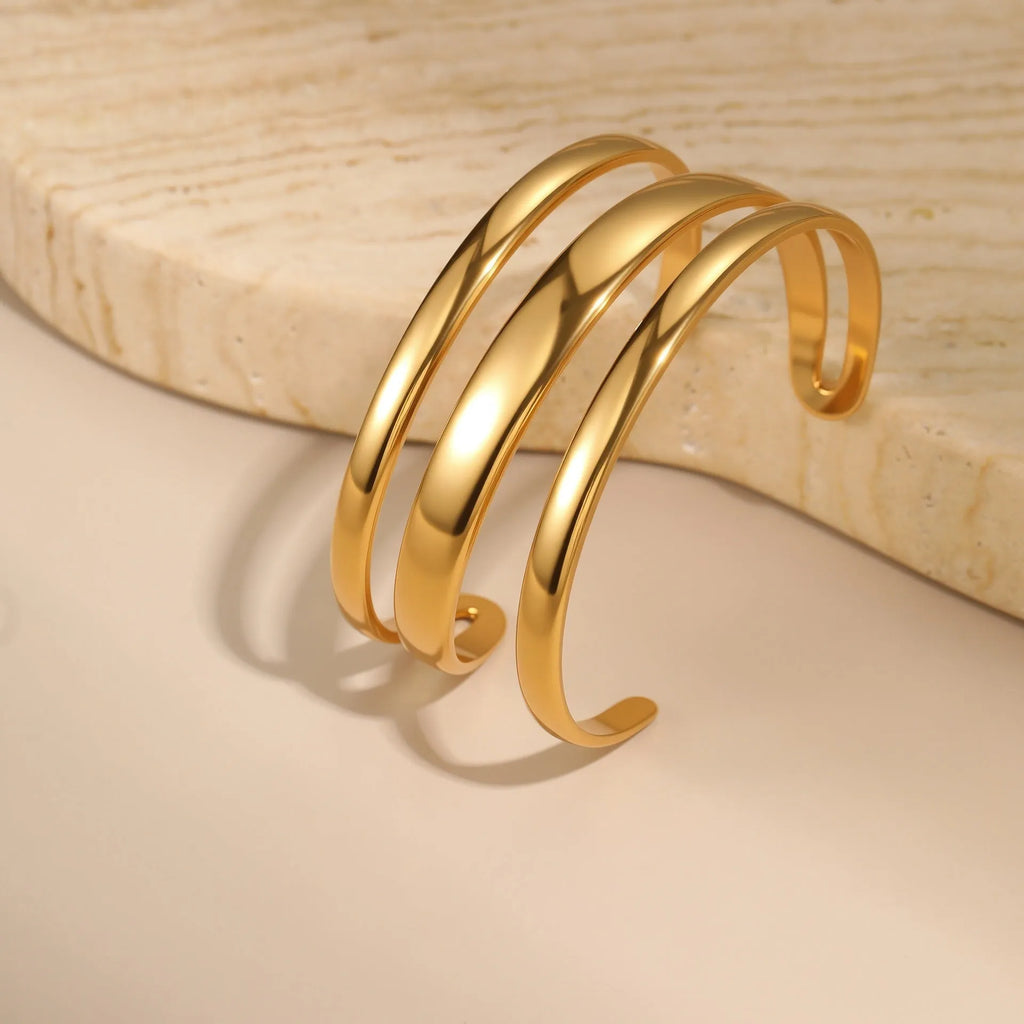 Geometric line design stainless steel women's bracelet with a simple opening clasp, shown in gold and steel colour options.