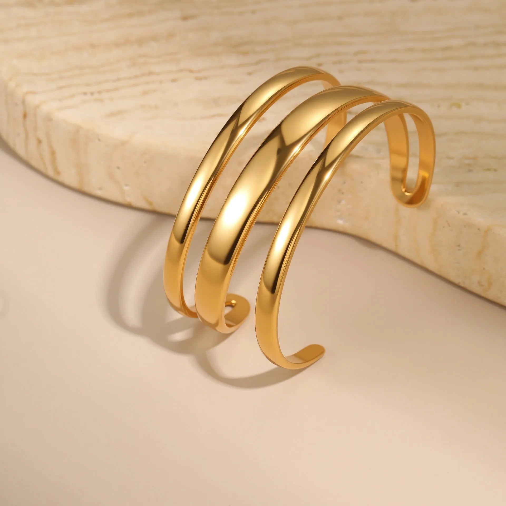 Geometric line design stainless steel women's bracelet with a simple opening clasp, shown in gold and steel colour options.