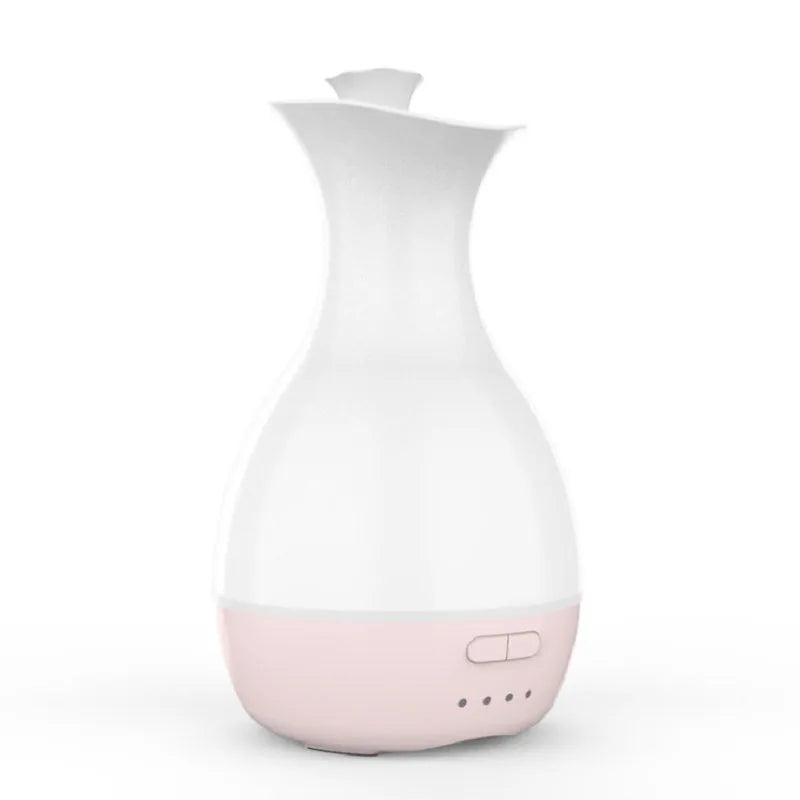 White ultrasonic aromatherapy diffuser and humidifier with colourful LED light misting on a wooden table.