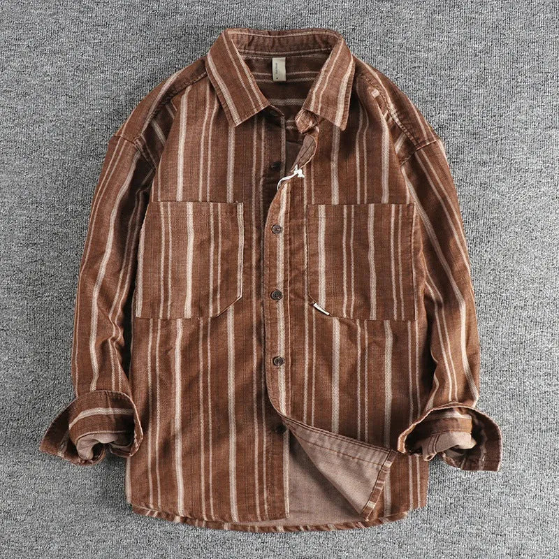 Man wearing a vintage-style striped overalls shirt in apricot colour with long sleeves and loose fit.