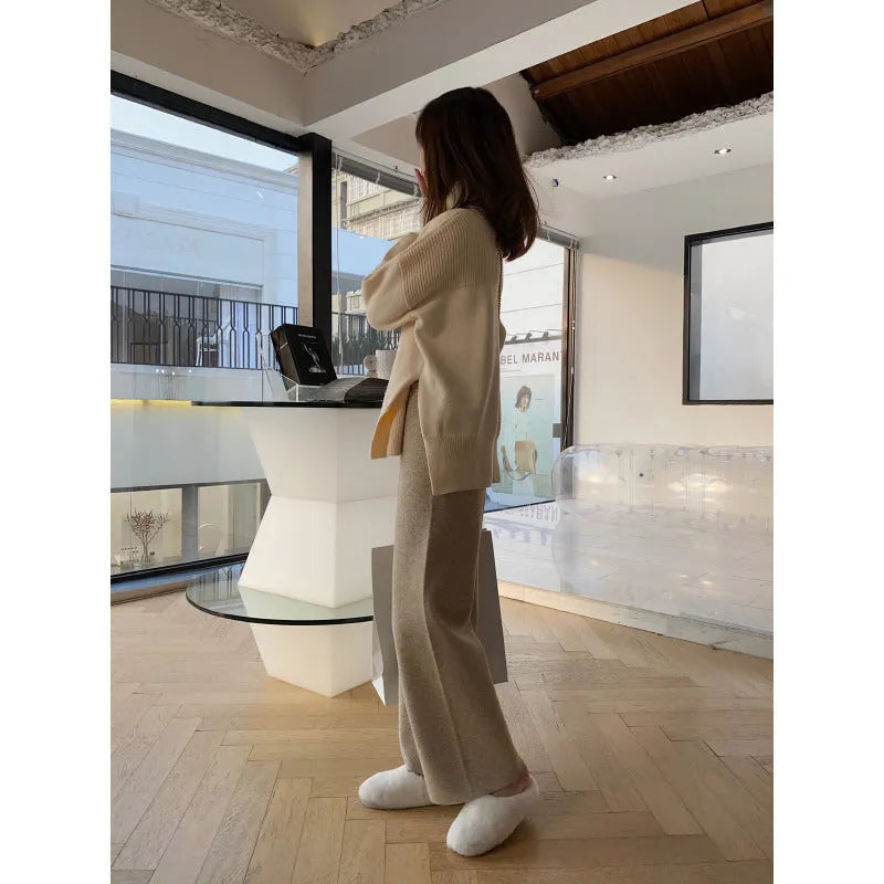 Women's cream white thick knitted wide-leg trousers with a high waist and drooping hem laid flat.