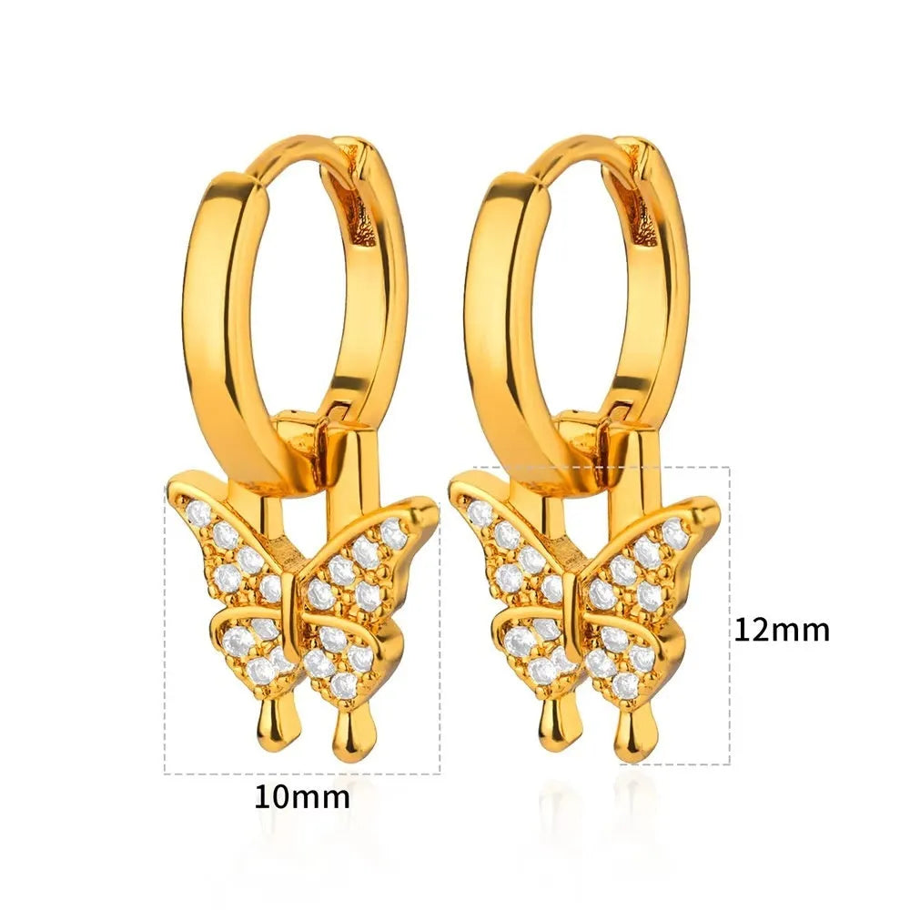 Butterfly-shaped copper earrings with geometric heart, star and bow patterns in metallic finish