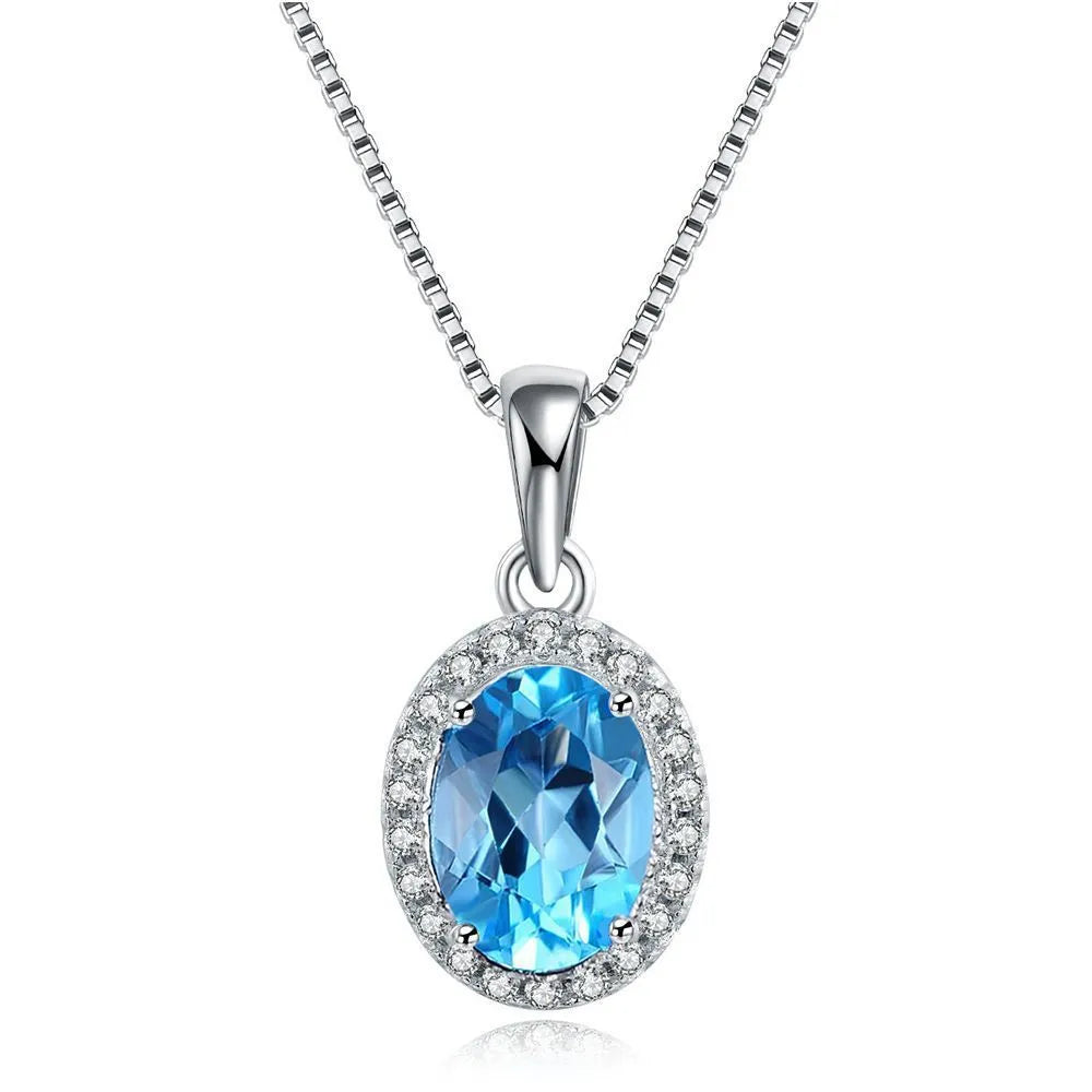 Women's sterling silver jewellery set with blue topaz gemstones in geometric design including earrings, ring, pendant, and necklace