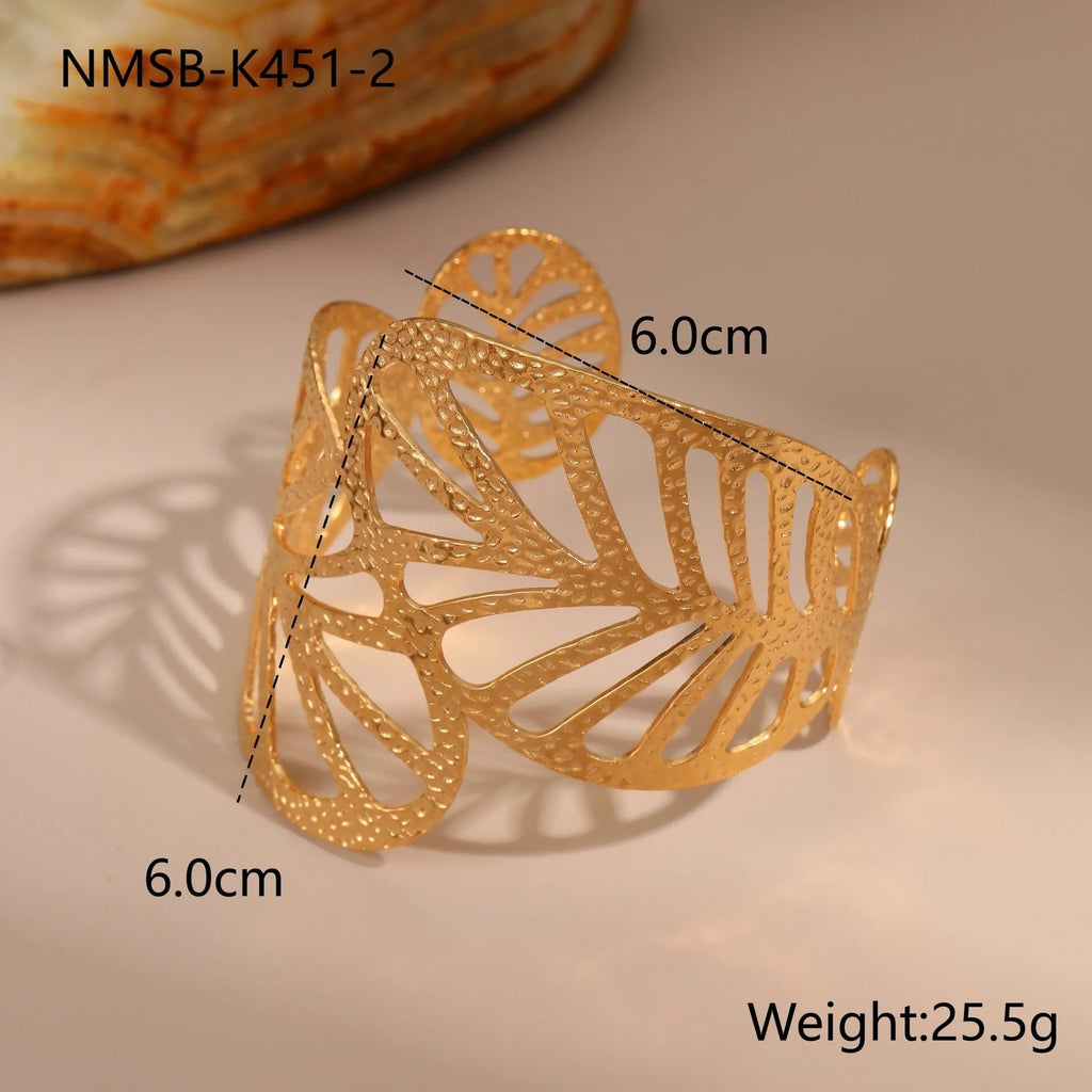 Gold stainless steel wristband with geometric leaf bow design on white background