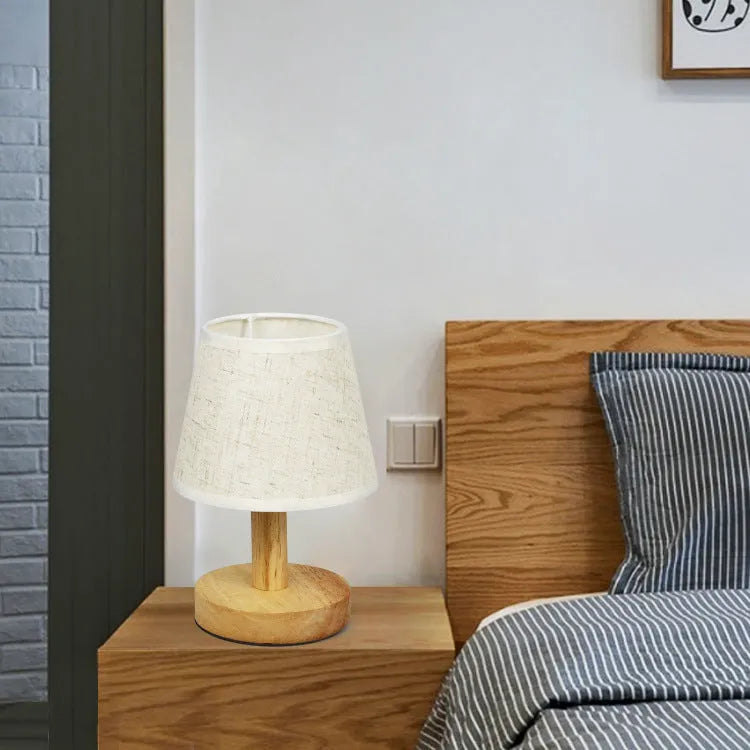 Vintage pleated table lamp with jute shade and bamboo base on a wooden table.