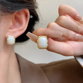 A pair of geometric circular metal earrings with hand-woven detail, in a vintage Korean style.