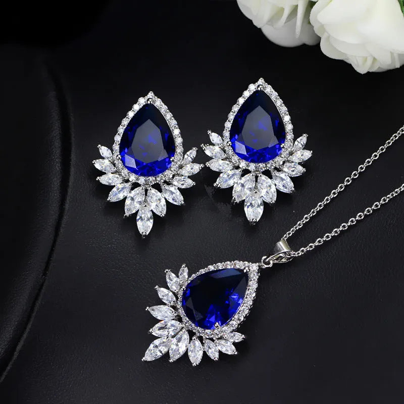Silver-tone formal jewellery set with simulated diamonds and crystals, includes necklace and bracelet in blue, red, or white.