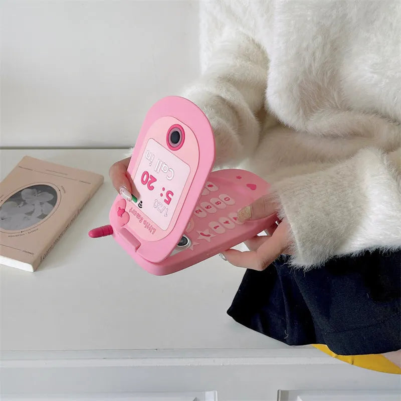 Light pink silicone flip phone case with mirror for iPhone, featuring a cute cartoon design.