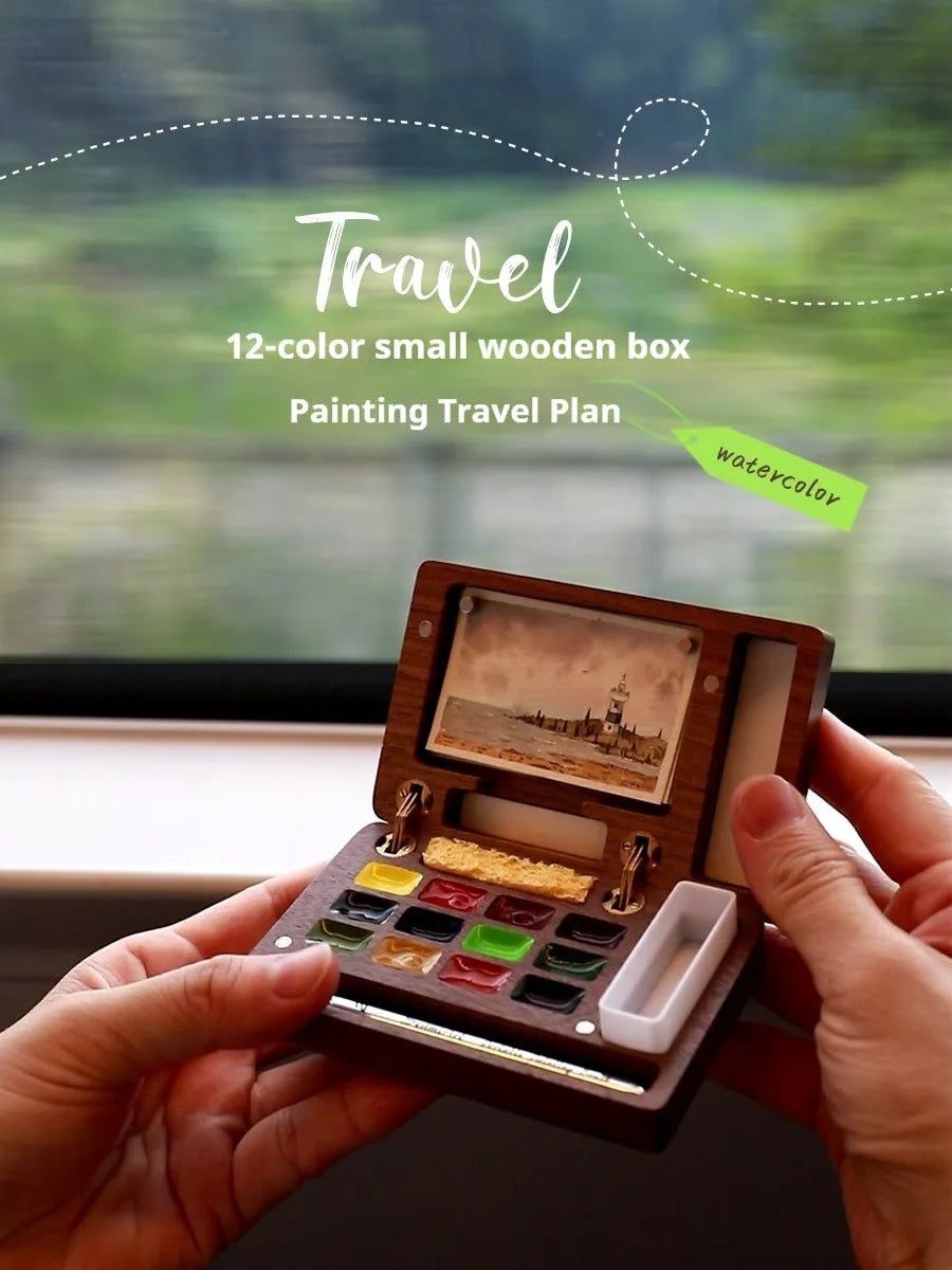 Mini walnut wooden watercolour paint box set with leather carry case, open to show professional artist pigments.