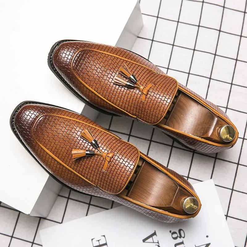 Men's black pointed toe slip on shoes with a gold tassel detail on the upper.