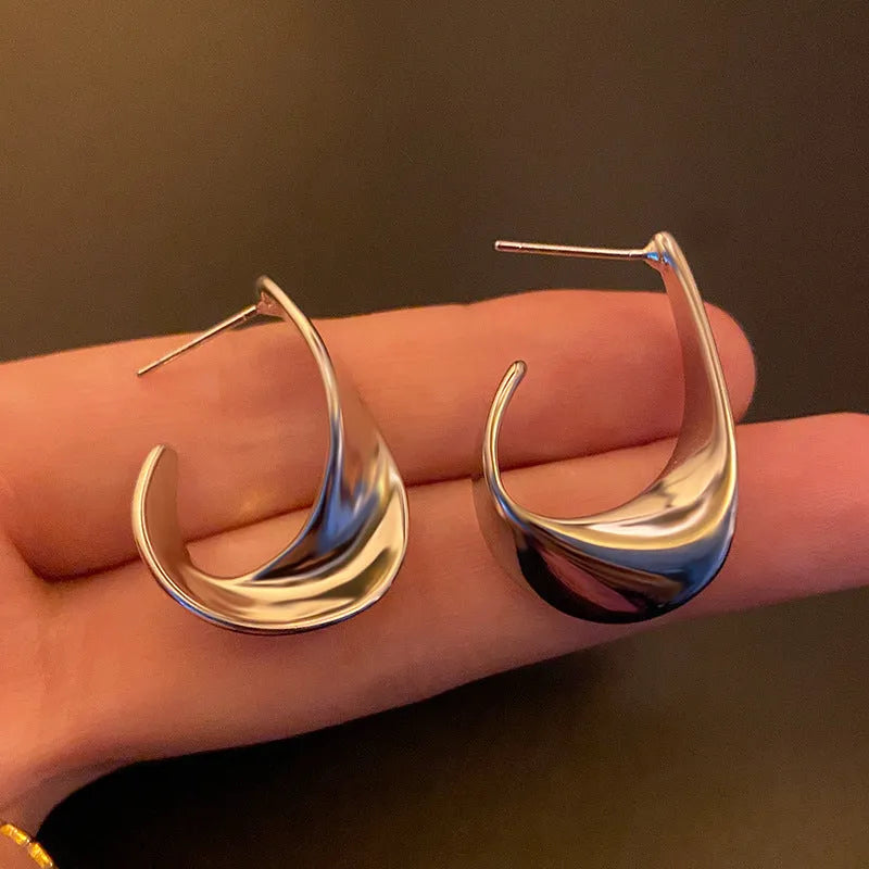 Twisted geometric metal earrings with electroplated gold finish and round design elements