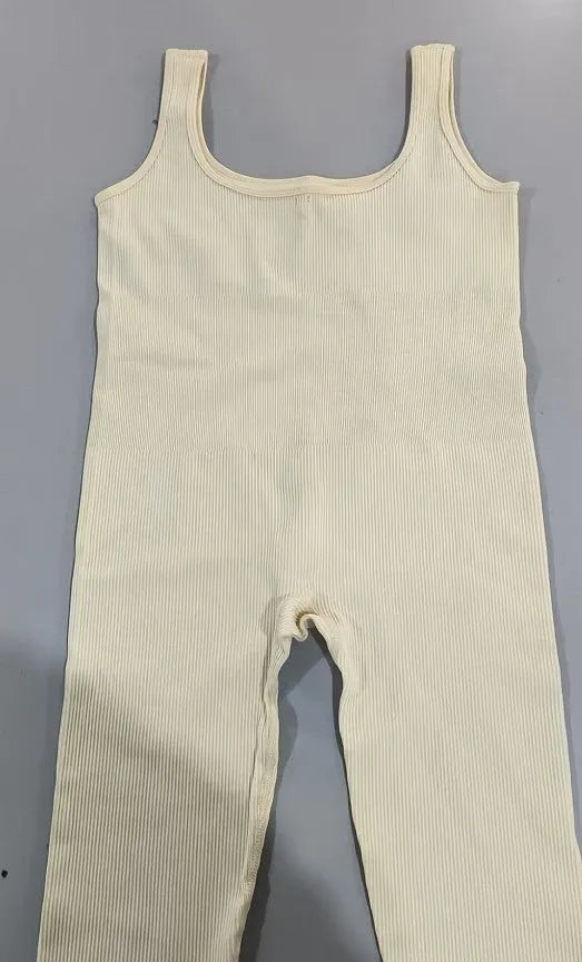 Women's beige suspender tank top tights with button detailing and long sleeves made from spandex fabric.