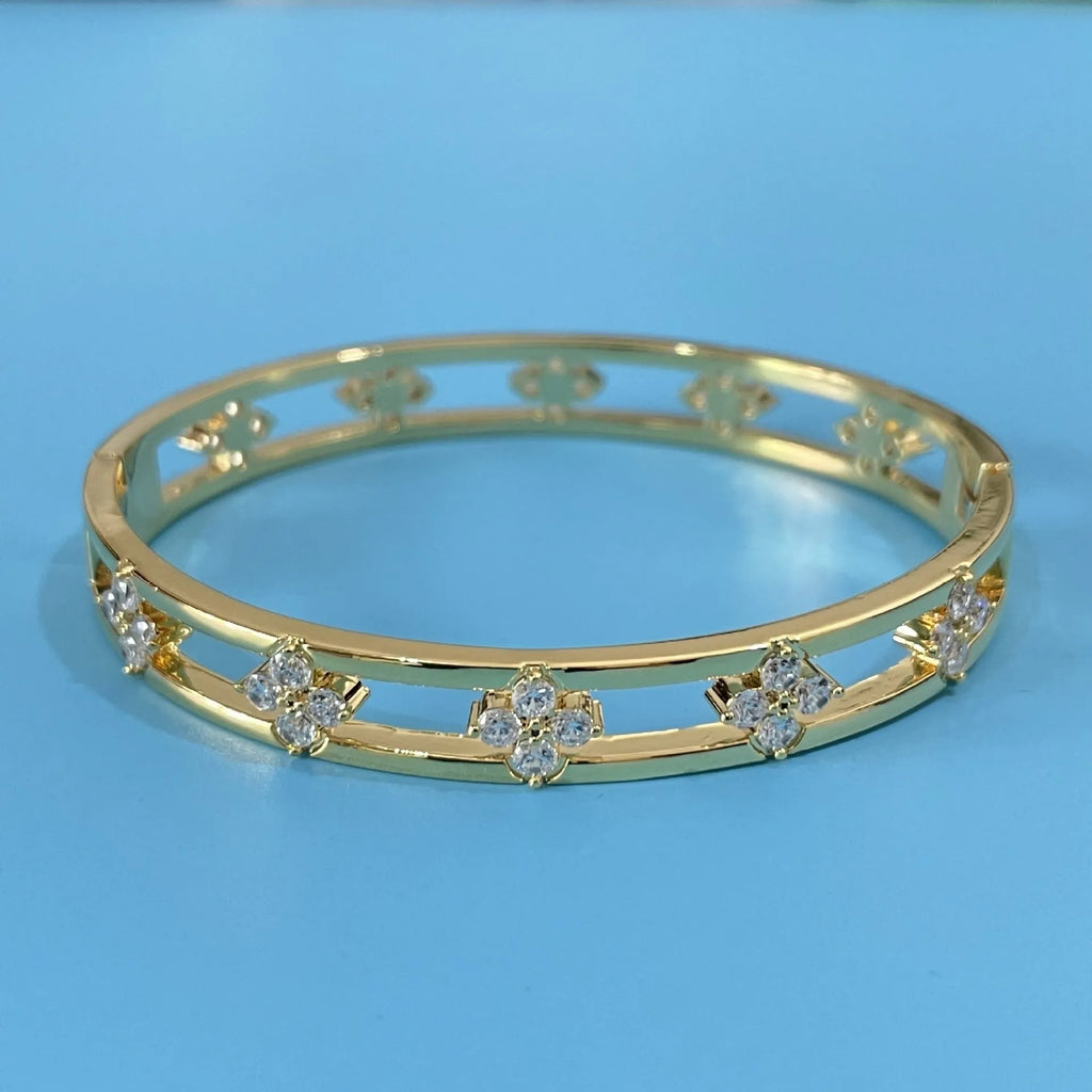 Women's hollow bracelet with four-leaf clover charm and zircon stones in gold or silver tone
