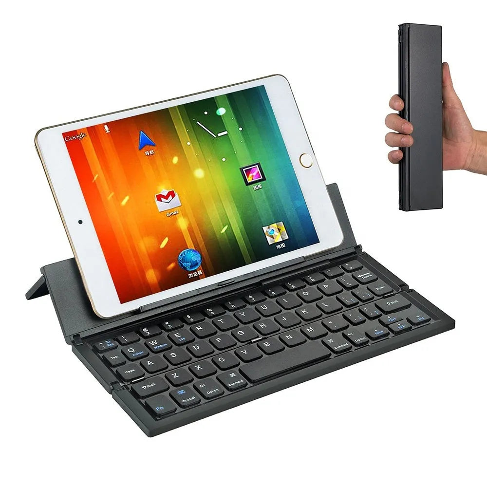 A black mini folding wireless Bluetooth keyboard shown open next to a tablet.