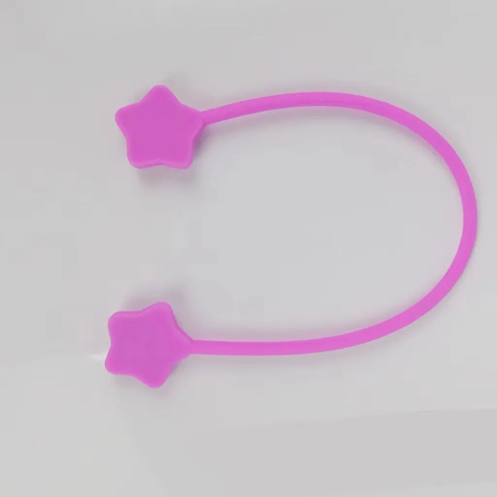 Purple silicone star-shaped magnet winder for clipping onto and organising headphone or phone charging cables.