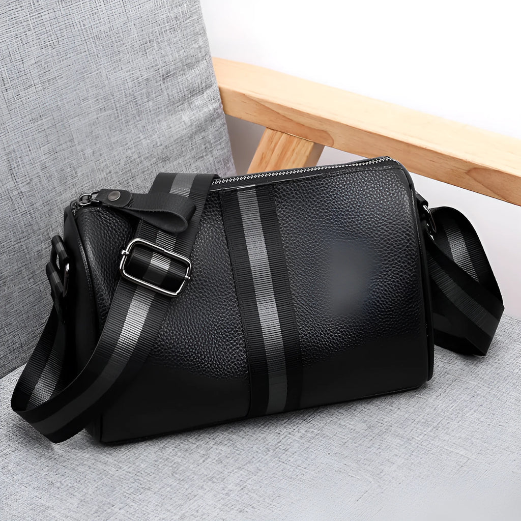 Black genuine leather crossbody bag with adjustable strap and large 24x16x13cm capacity.