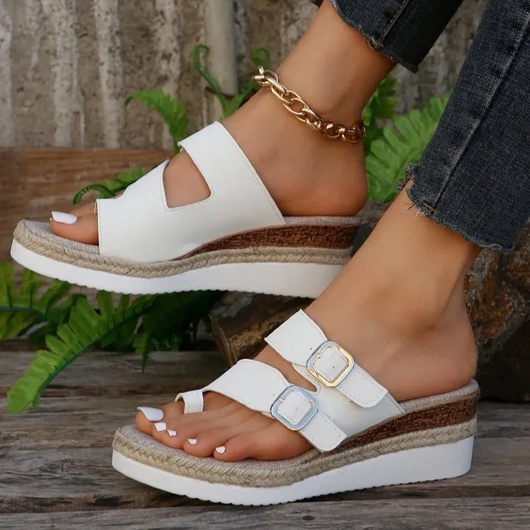 White patent leather women's wedge sandals with woven finger fit straps and a peep toe.
