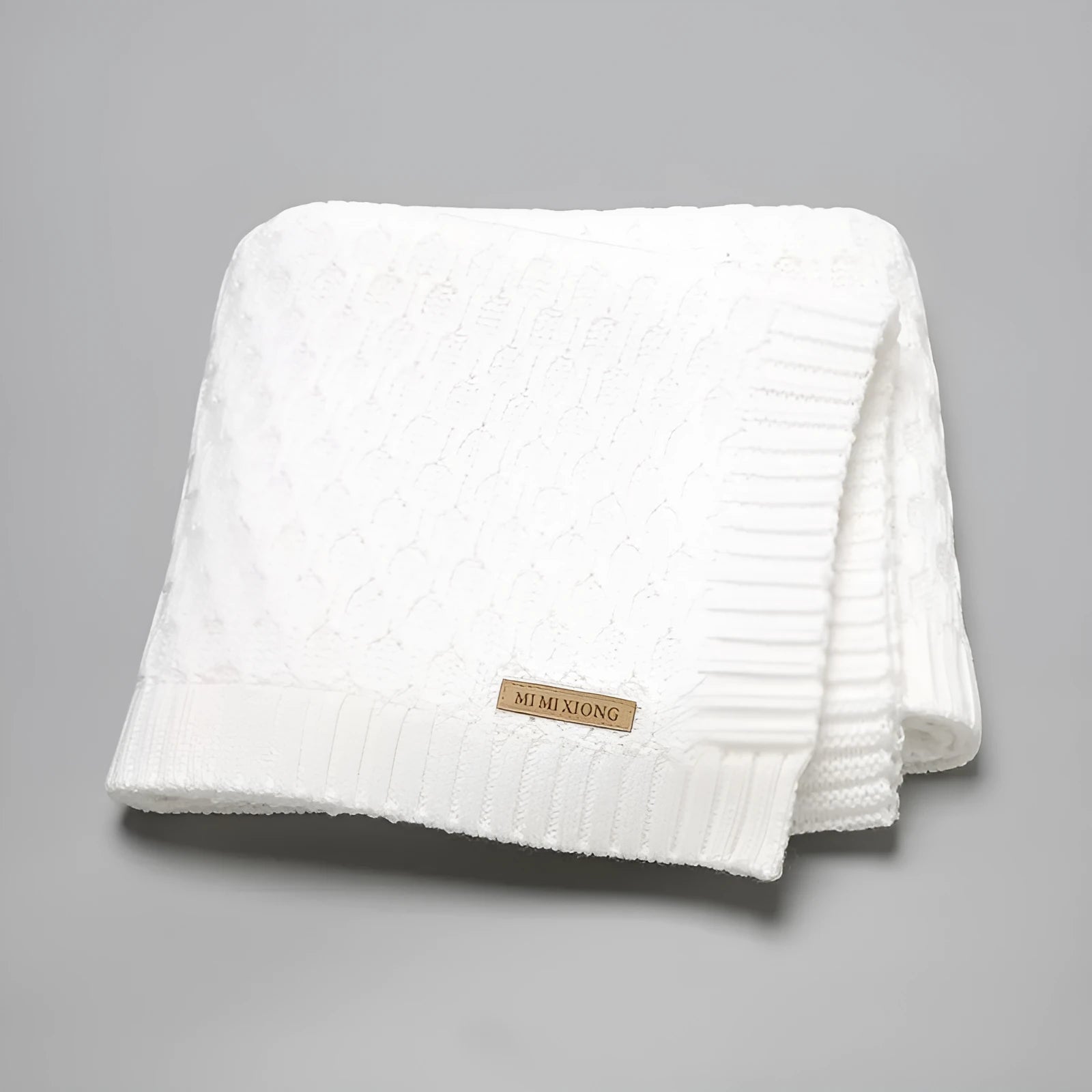Solid colour infant hug blanket with textured lines, shown in acrylic fabric measuring 70 by 90 cm.
