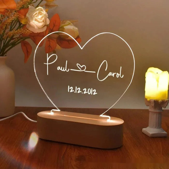 Custom transparent acrylic night light with engraved names and date, lit by LED base.