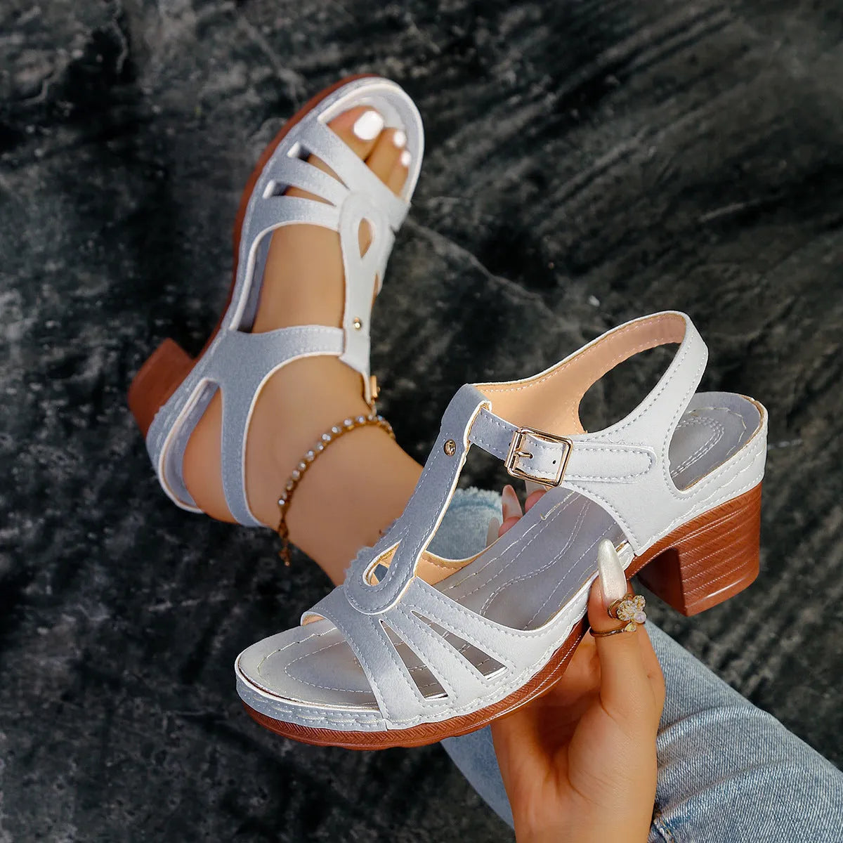 Women's black peep toe wedge sandals with a buckle fastening on a white background.