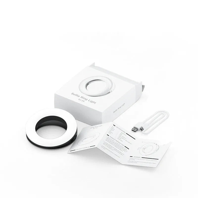 Compact black LED selfie ring light for mobile phone with USB cable for recharging.