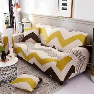 Geometric abstract printed stretch sofa slipcover covering a three-seater sofa with matching cushion covers.