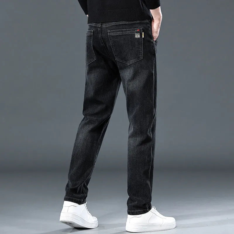 Man wearing slim straight blue grey casual trousers with a loose thin fit and zip fly.
