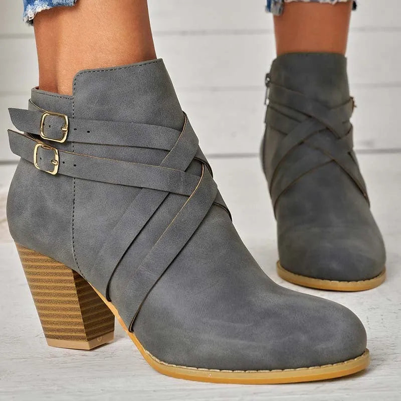 Women's black short boot with 7cm heel, side zipper, belt buckle, and rubber sole