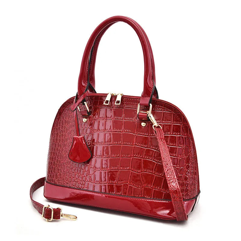 Shiny PU crossbody shoulder bag in shell shape showing black, brown, and red colour options