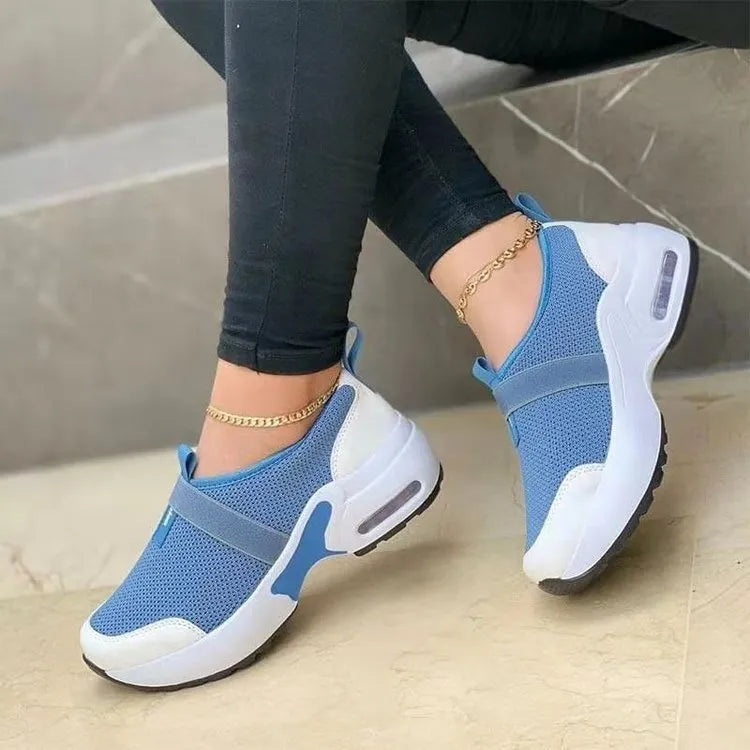 Women's flat sneakers in light grey with mesh upper, round toe, and rubber sole.