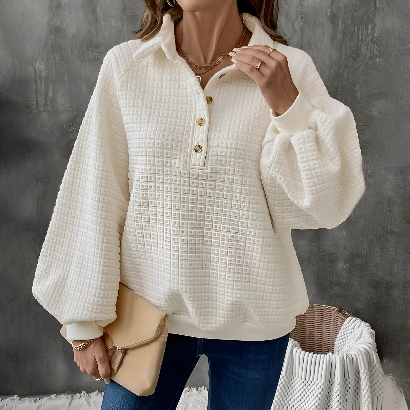Women's beige textured polo collar long sleeve sweater laid flat.