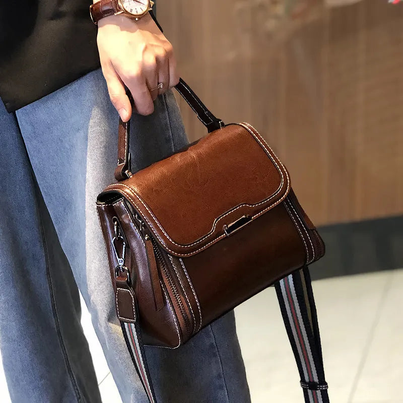 Women's brown genuine leather messenger bag with retro styling and multiple internal pockets