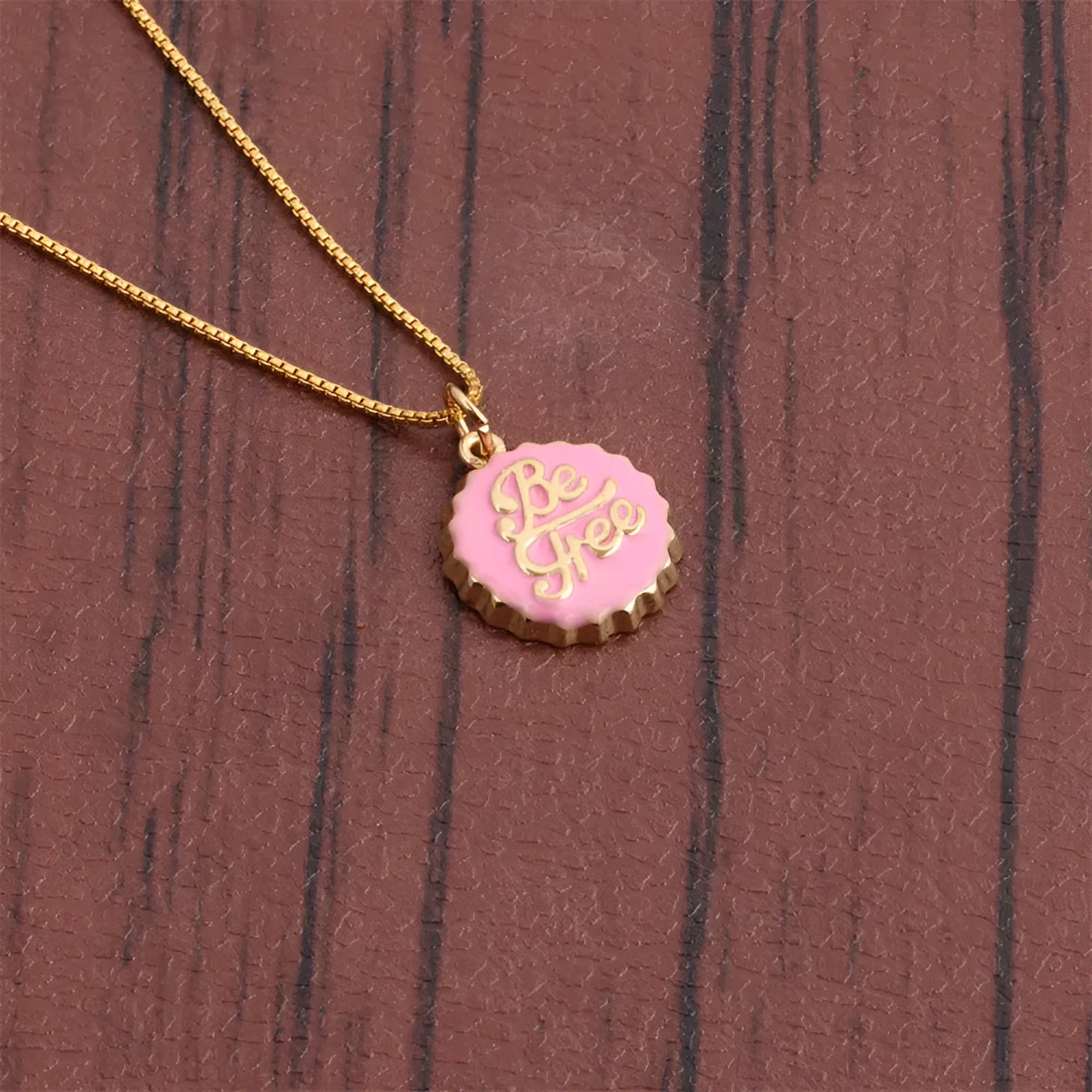 Copper bottle cap pendant necklace with gold plating on a box chain.
