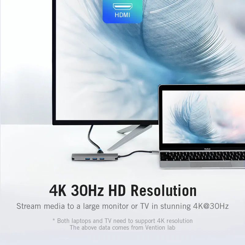 Deep grey USB-C multi-port hub with HDMI, three USB ports, Ethernet, and memory card slots on a desk.