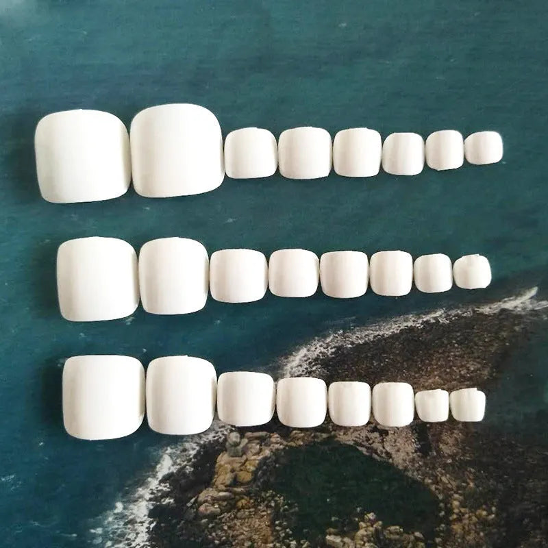 Set of white fake nails with a starry sky pattern, laid out for display.