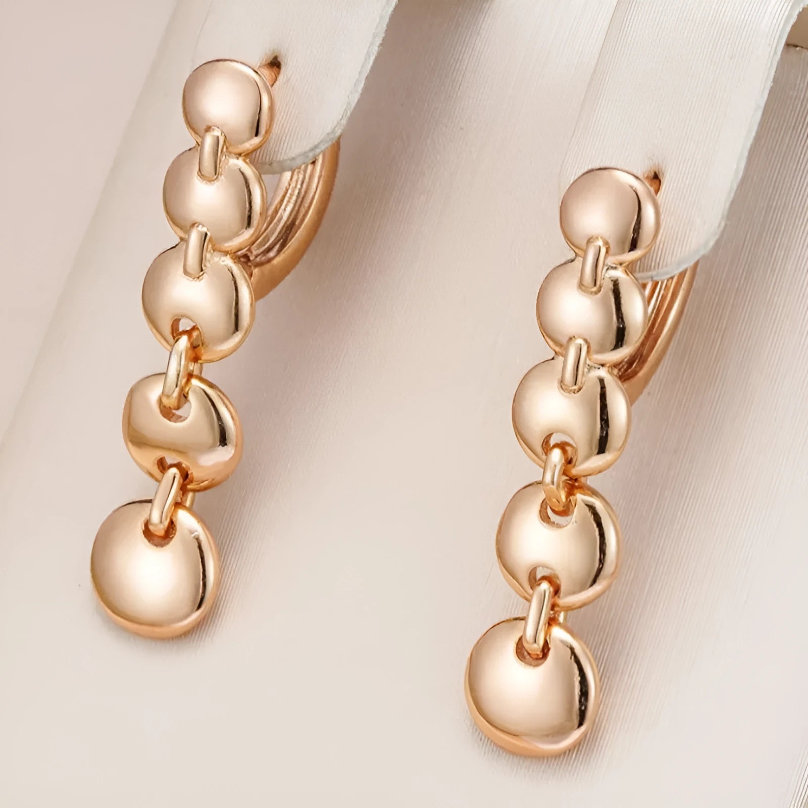 A pair of long gold-colour retro earrings with a woven round circle design made from copper.