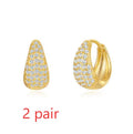 Golden brass earclip earrings with geometric round drop design on white background