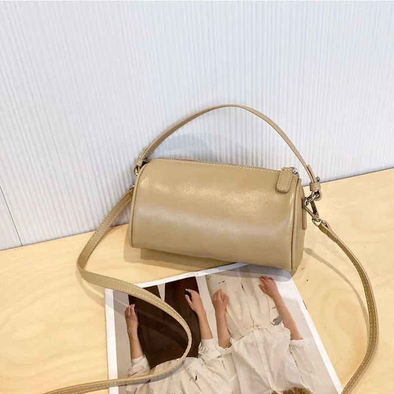Soft genuine leather cylindrical crossbody bag in street style, shown in black, with a single strap.