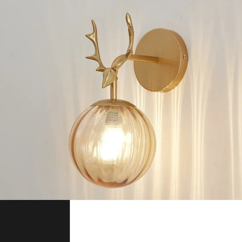 Nordic minimalist round glass wall lamp in golden finish mounted on a wall.