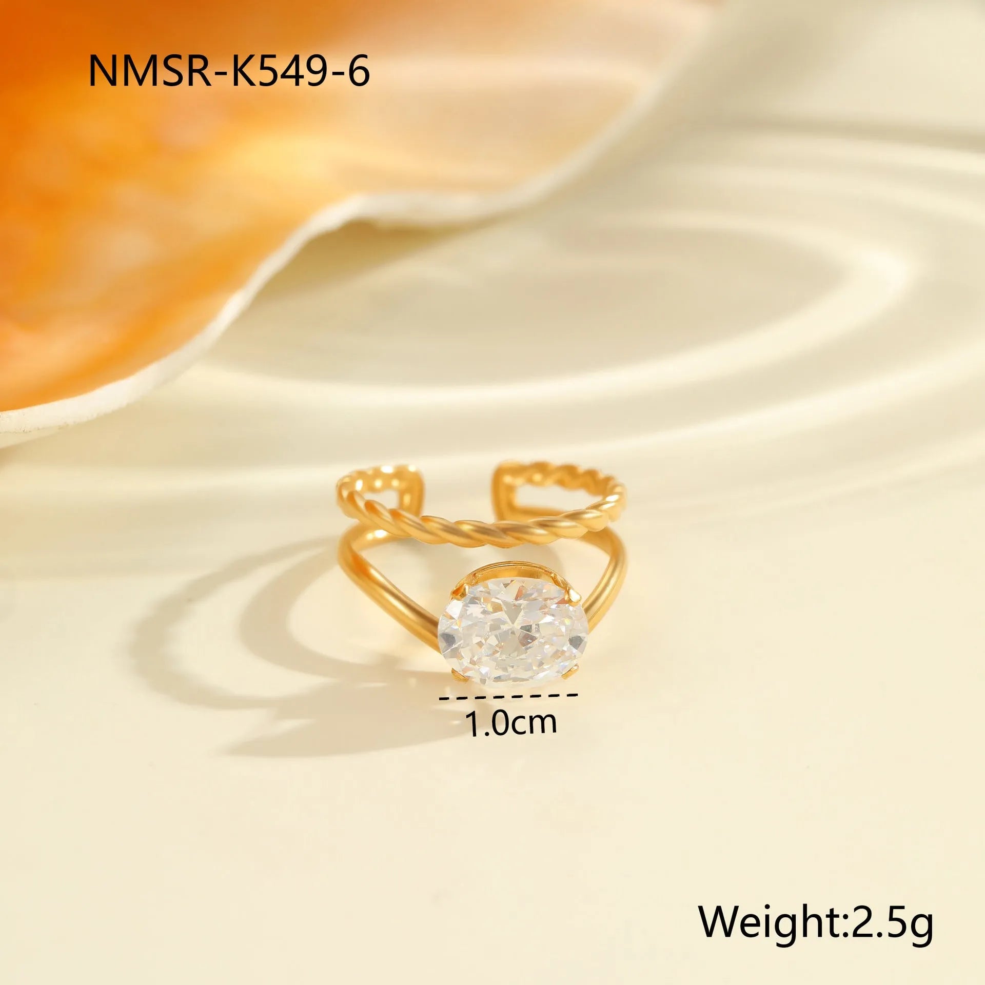 Gold inlaid zircon geometric heart and drop shape stainless steel ring on white background.